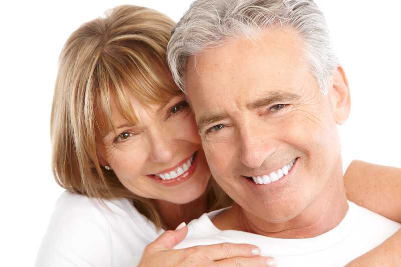 Elderly couple smiling with bright teeth after professional teeth whitening in Huntsville, AL