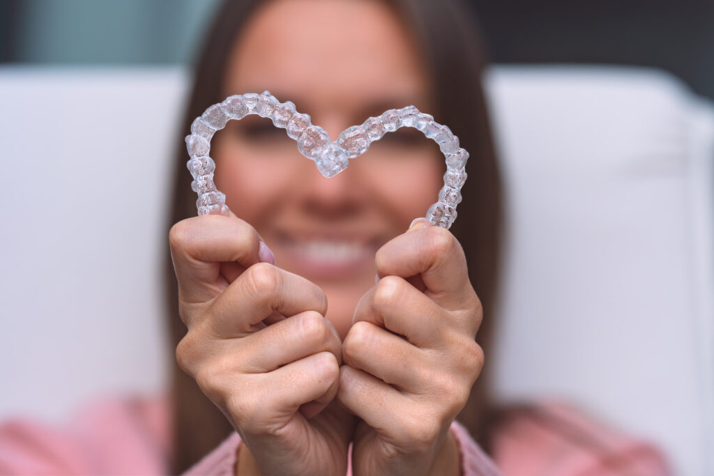 Invisalign clear aligner held in heart shape for orthodontic treatment Invisalign clear aligner held in heart shape for orthodontic treatment